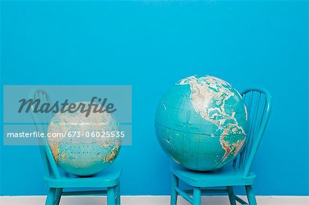Two globes placed on two chairs facing each other