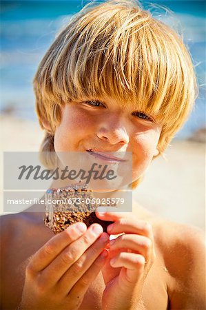 Young boy taking bite of large brownie