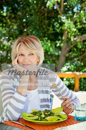 Woman eating salad outdoors
