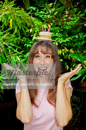 Woman with birthday cupcake on head