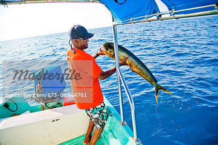 Man with fish on charter fishing boat
