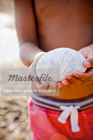 Boy with moonsnail shell in his hands