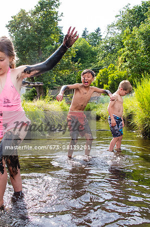 Children playing in a muddy creek