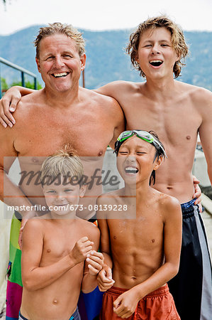 Portrait of a man and three boys in swimming trunks - Stock Photo -  Masterfile - Premium Royalty-Free, Code: 673-08139228