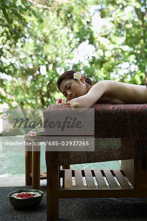 Young woman lying down on massage table