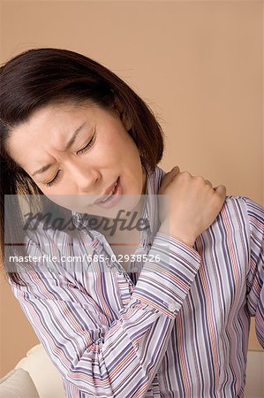 A woman suffering from pain in shoulder