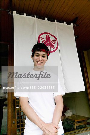 Young man standing in front of restaurant