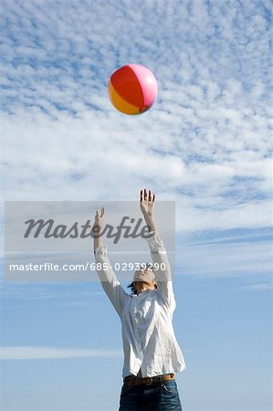 Young man playing with beach ball
