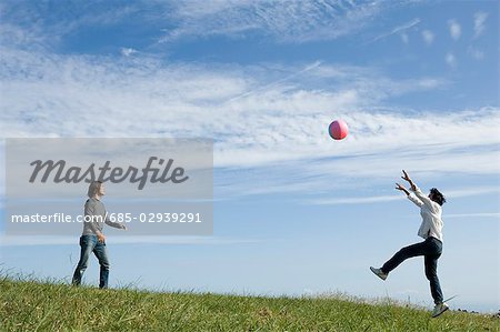 Two young men playing with beach ball