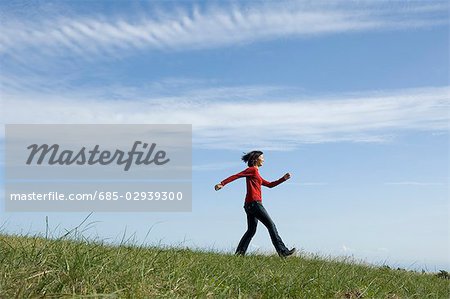 Young woman skipping in field