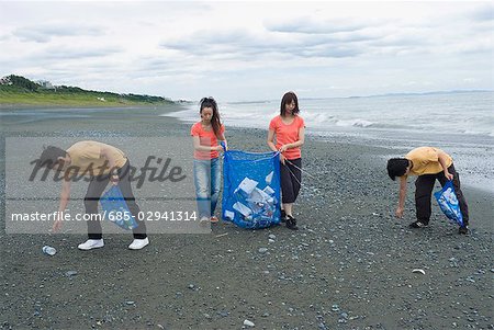 Young people cleaning beach
