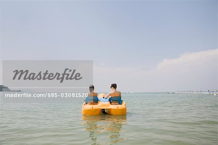 Two young women riding on pedal boat