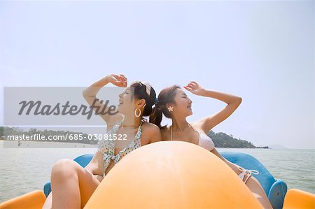 Two young women riding on pedal boat