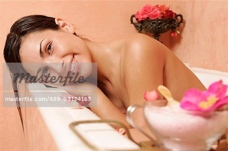 Woman in bath tub with petals