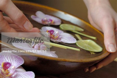 Hand bath with orchid blossoms ad limes