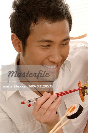 Man eating sushi with chopsticks