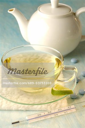 Tea with clinical thermometer, teapot and pills
