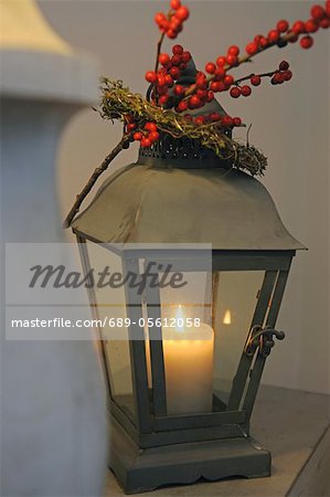 Lantern with burning candle and twig