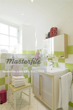 Bathroom with sink, mirror and towels on chair