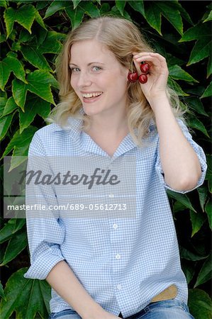 Happy young woman with cherries