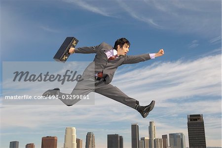 Business man running mid-air above city