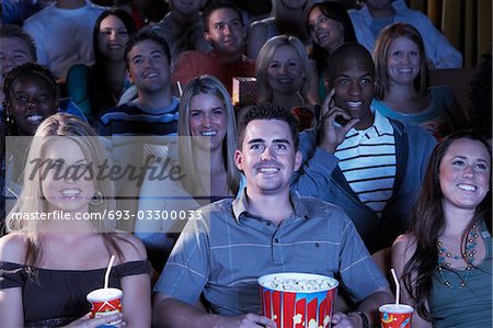 People holding soda and popcorn, Watching Movie in Theatre