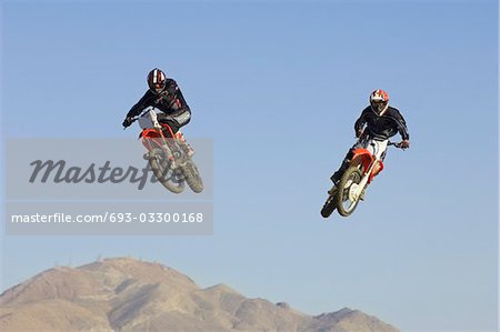 Two motocross Racers in mid-air