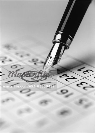 Tip of fountain pen marking date in calendar, (b&w), (close-up)