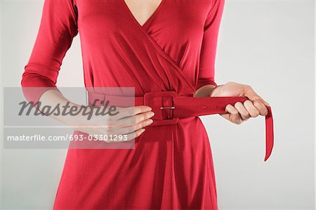 Businesswoman adjusting belt, mid section