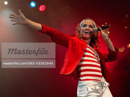 Young Woman Singing on stage in Concert, low angle view