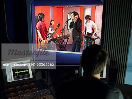 Band in recording studio, technician in foreground