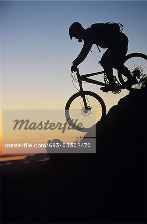 Mountain biker riding down slope
