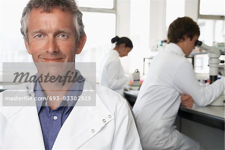 Smiling Lab Worker, colleagues behind