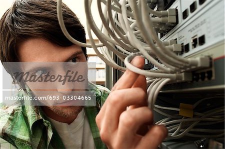 Man working on network switch, close-up.