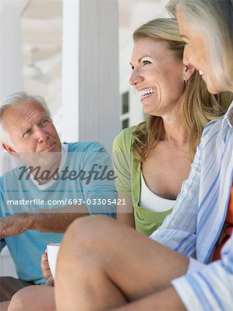 Three people sitting on verandah