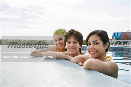 Three teenagers (16-17) in swimming pool, portrait