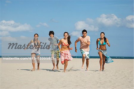 Group of teenagers (16-17) running on beach