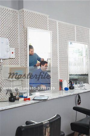 Barber cutting business mans hair in barber shop