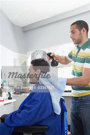 Barber preparing man for haircut in barber shop