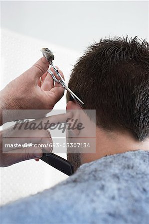 Barber cutting mans hair in barber shop