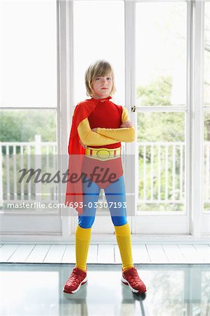 Portrait of young boy (7-9) in superhero costume, indoors