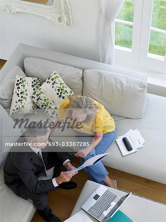 Woman sitting on sofa with financial advisor, elevated view