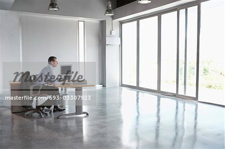 Man sitting at desk in empty office building