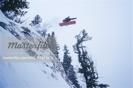 Person on snowboard, jumping, low angle view