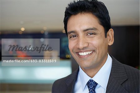 Business man standing in hotel lobby, portrait, close up