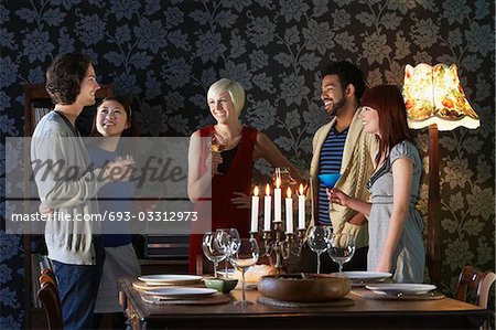 Group of people smiling, standing by dining table