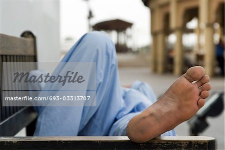 Dubai, UAE, man taking rest on park bench along boardwalk in Bur Dubai