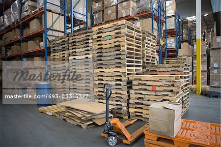 Wooden pallets stacked in distribution warehouse