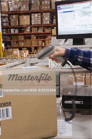 Man scanning bar code in distribution warehouse