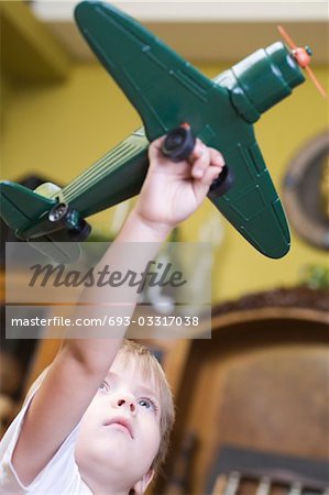 Boy playing with model airplane in home